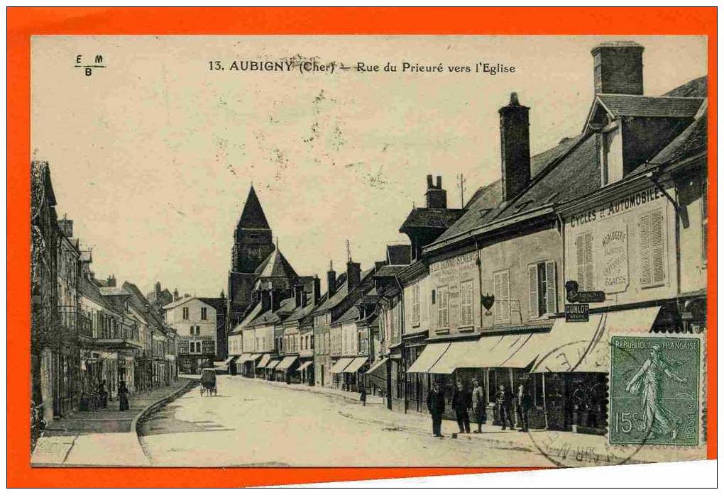 AUBIGNY SUR NERE 1924 RUE DU PRIEURE EGLISE COMMERCE CYCLE AUTOMOBILE HORLOGERIE BIJOUTERIE CARTE EN BON ETAT - Aubigny Sur Nere