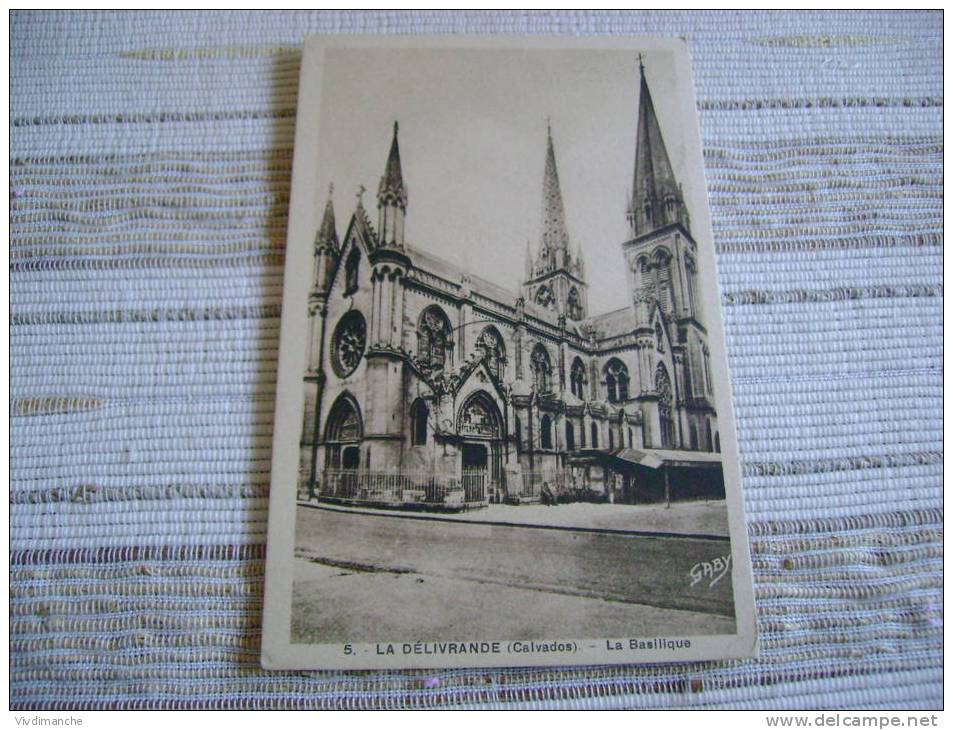 14 - LA DELIVRANDE -LA BASILIQUE - BATIMENT BATI CONTRE LA BASILIQUE A DROITE - ECRITE ANNEES 30 CPA  - ANIMEE - La Delivrande