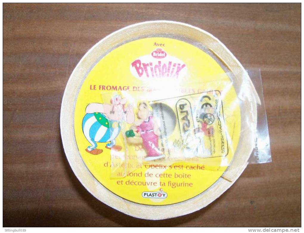 ASTERIX. Boîte à Fromage Pub BRIDEL, BRIDELIX. Couvercle Illustré Avec Obélix Et A. + 1 Figurine PLASTOY. BONEMINE. 1999 - Advertisement