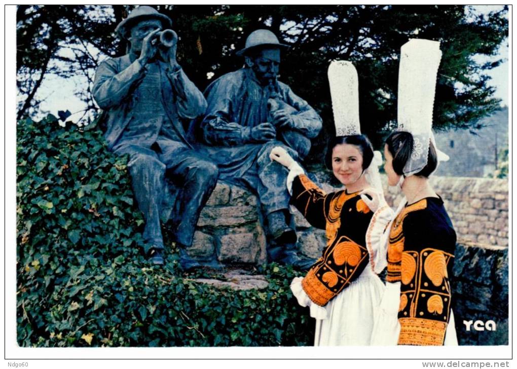 Plozevet - Jennes Filles En Costume Du Pays Devant Le Monument Aux Sonneurs Bigoudens - Plozevet