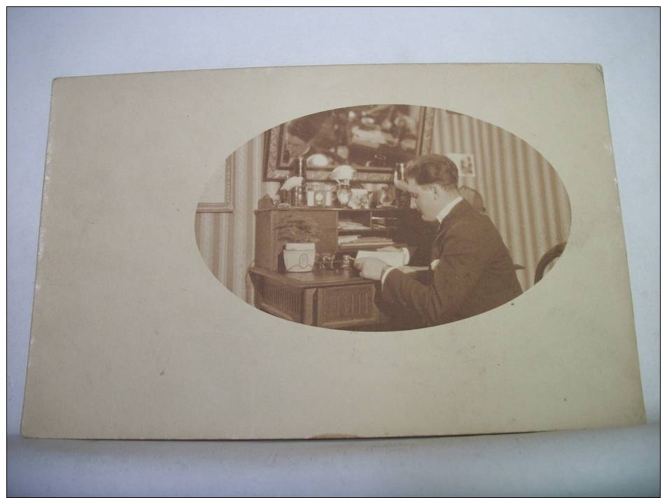 CARTE PHOTO -  JEUNE HOMME EN PLEINE LECTURE A SON BUREAU -  ANIMATION A IDENTIFIER - Photographie