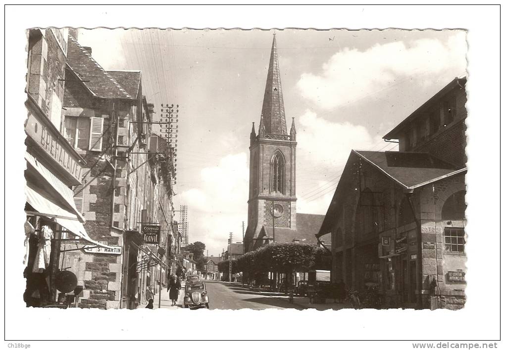 CPA -50 - Manche : Bréhal : La Rue Principale Et L'Eglise : Magasins , Voitures ... - Brehal