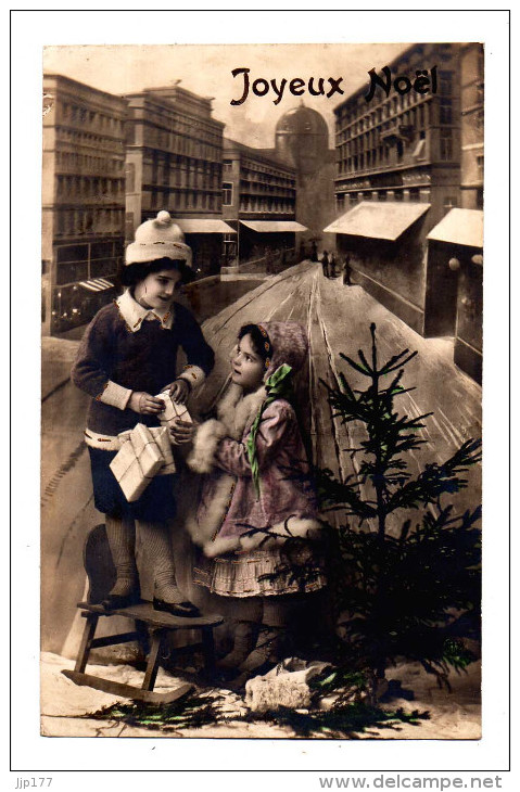 Joyeux Noel Carte Avec 2 Fillette Peut Etrre Soeurs Manteau Et Bonnet De Fourrure Avec Cadeaux Et Sapin Dans Une Ville - Autres & Non Classés