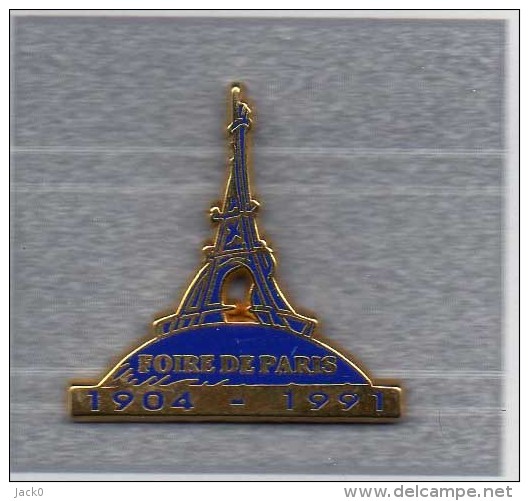 Pin´s  Ville, Foire  De  PARIS  1904 - 1991  Avec  La  Tour  Eiffel  Cartouche  Bleu  Signé  Decat - Villes