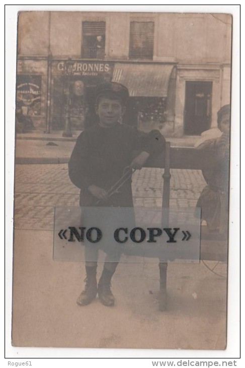 CARTE  PHOTO  -  Jeune Garçon  Sur Un Banc  ( Non Localisée ) Vitrines De Magasins Aux Dos - Silhouettes