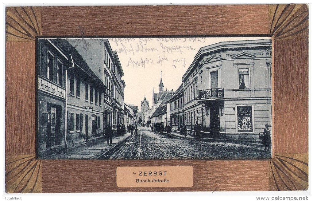 ZERBST Bahnhofstrasse Belebt Geschäfte Friseur Barbier Tabake Cigarren Holzrand Imitation 30.7.1906 Gelaufen - Zerbst