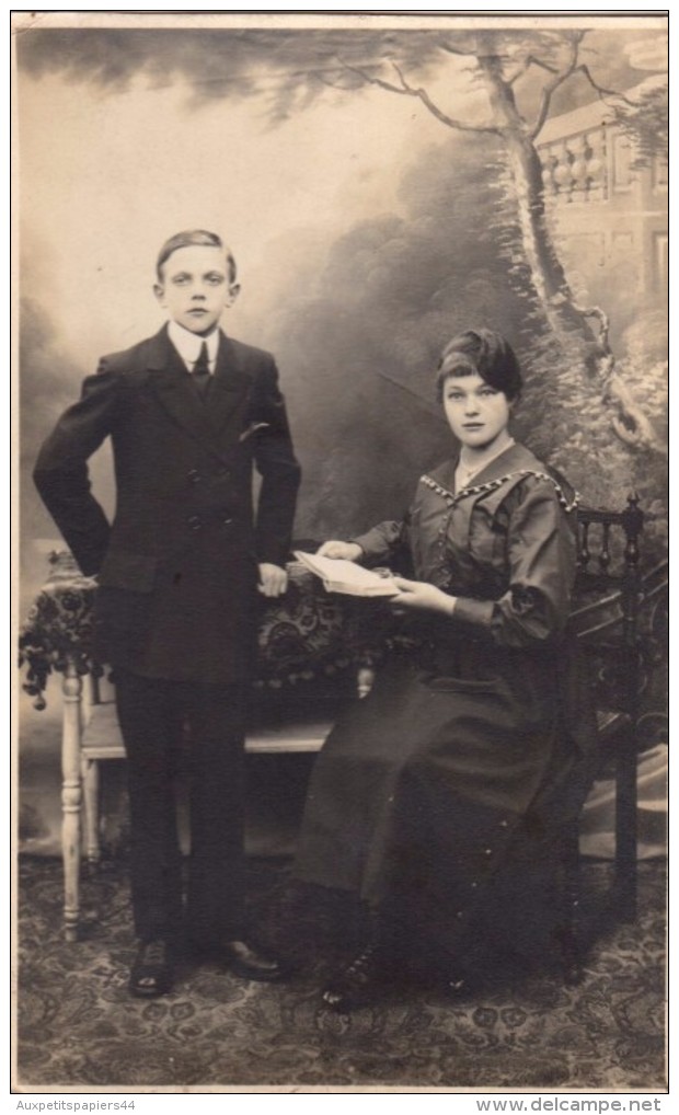 Carte Photo Originale Couple - Beaux Jeunes Gens En Studio, Femme à La Lecture Sur Fauteuil - Personnes Anonymes