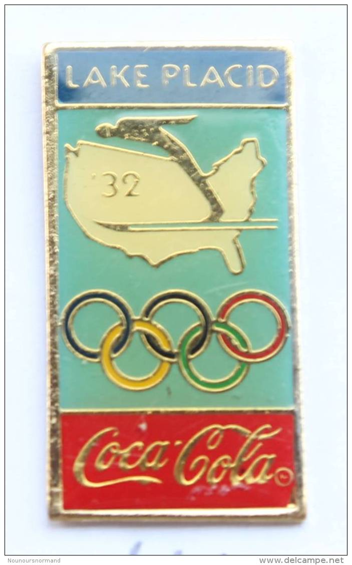 Pin's  COCA COLA - 3° J.O D'hiver LAKE PLACID 1932 - Skieur - Carte Des USA - Anneaux Olympiques - Premier - G1162 - Coca-Cola