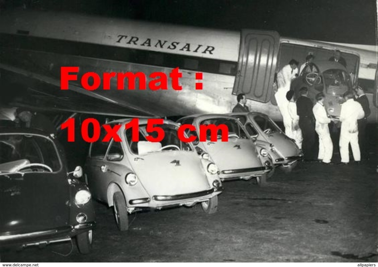 Reproduction D'une Photographie D'hommes Débarquant à La Main Une Isetta D'un Avion Transair - Autres & Non Classés