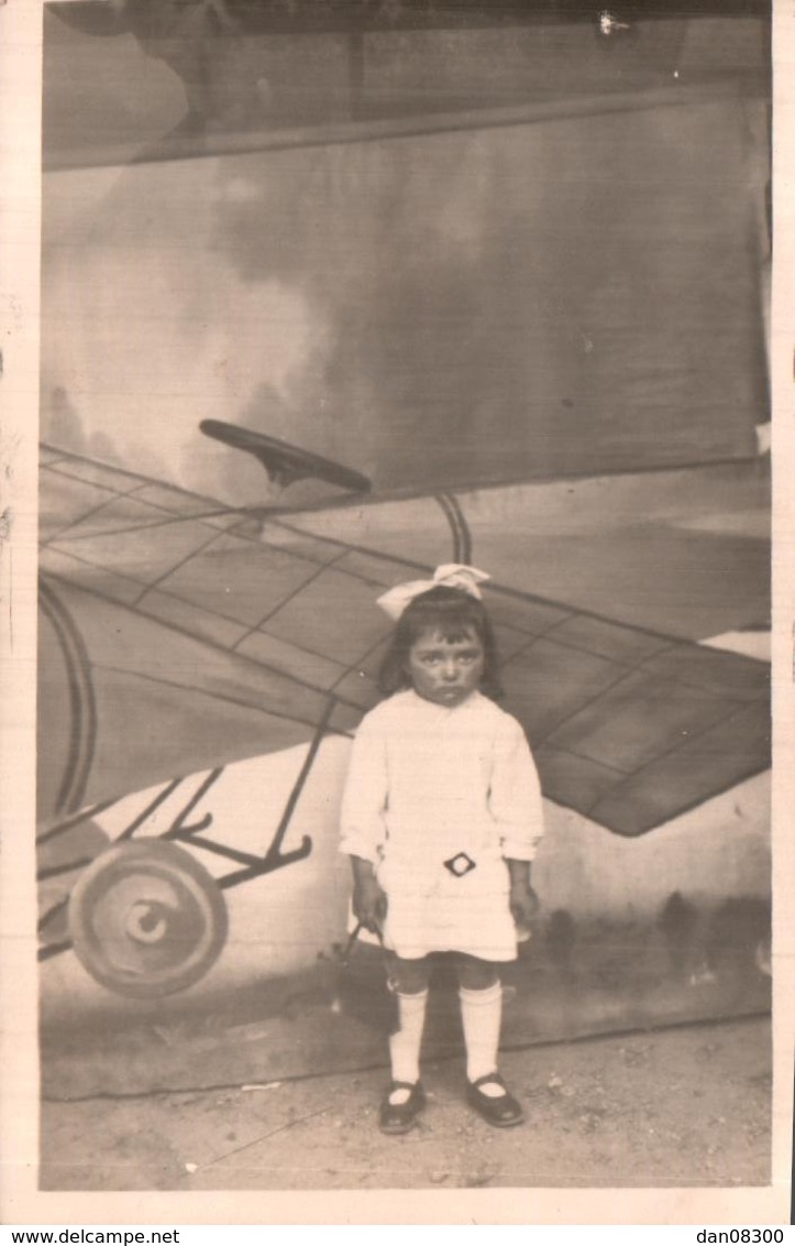 CARTE PHOTO SANS LEGENDE UNE FILLETTE BOUDEUSE EN ROBE BLANCHE DEVANT UN DESSIN D'AVION PAS CIRCULEE - To Identify