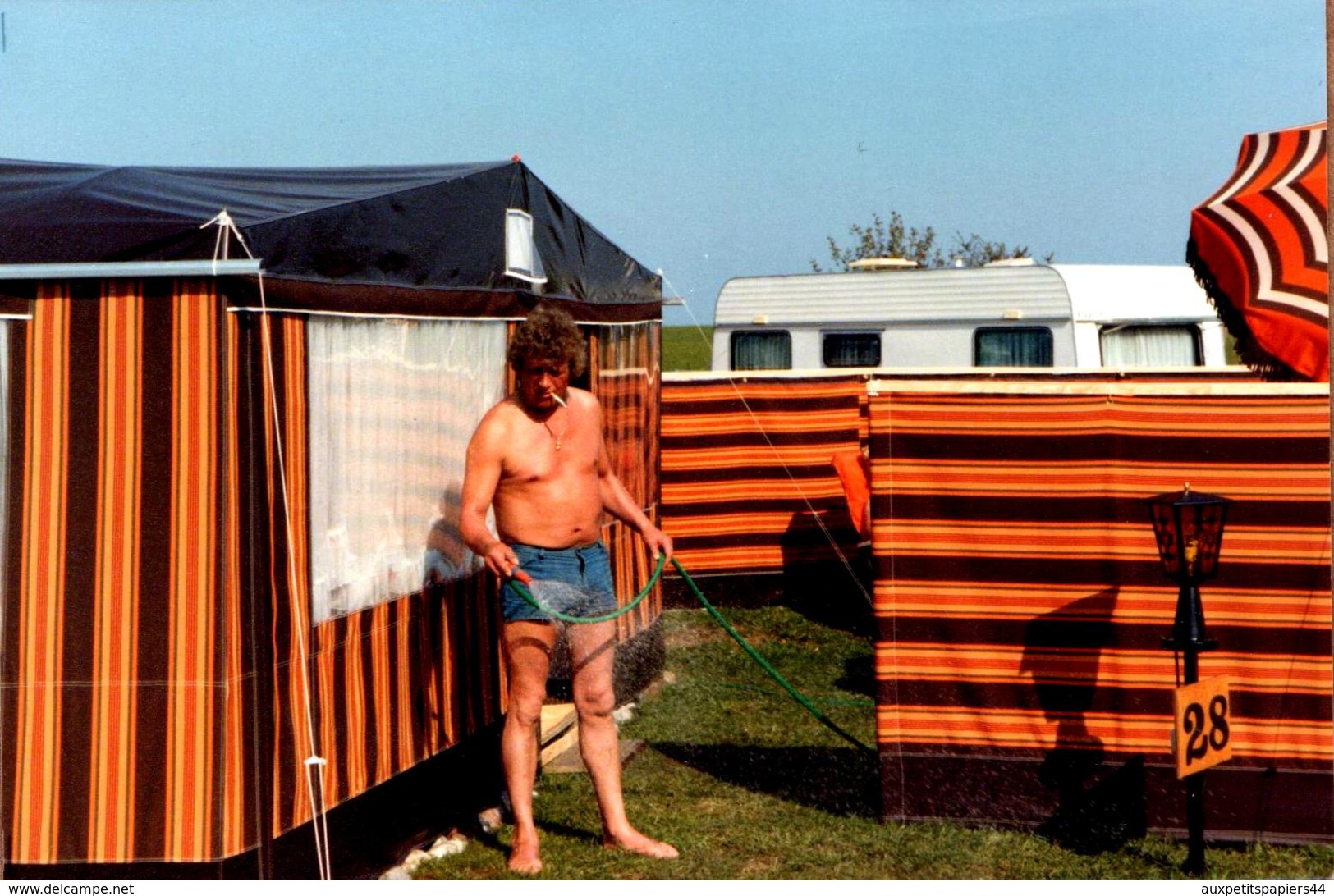 Photo Originale Camping, Caravane Et Playboy Sexy à La Cigarette Arrosant Sa Pelouse En 1980 - Personnes Anonymes