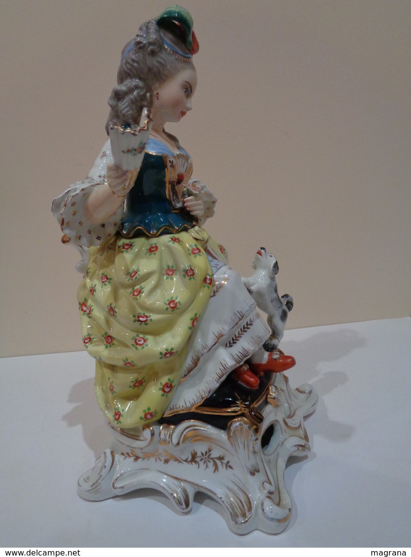 Antigua figura de porcelana (licorera, bote). Mujer sentada con abanico y perro. Estilo Viejo París.