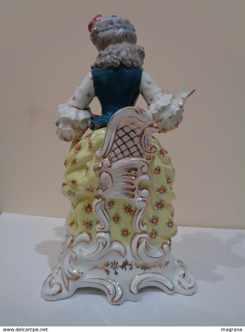 Antigua figura de porcelana (licorera, bote). Mujer sentada con abanico y perro. Estilo Viejo París.