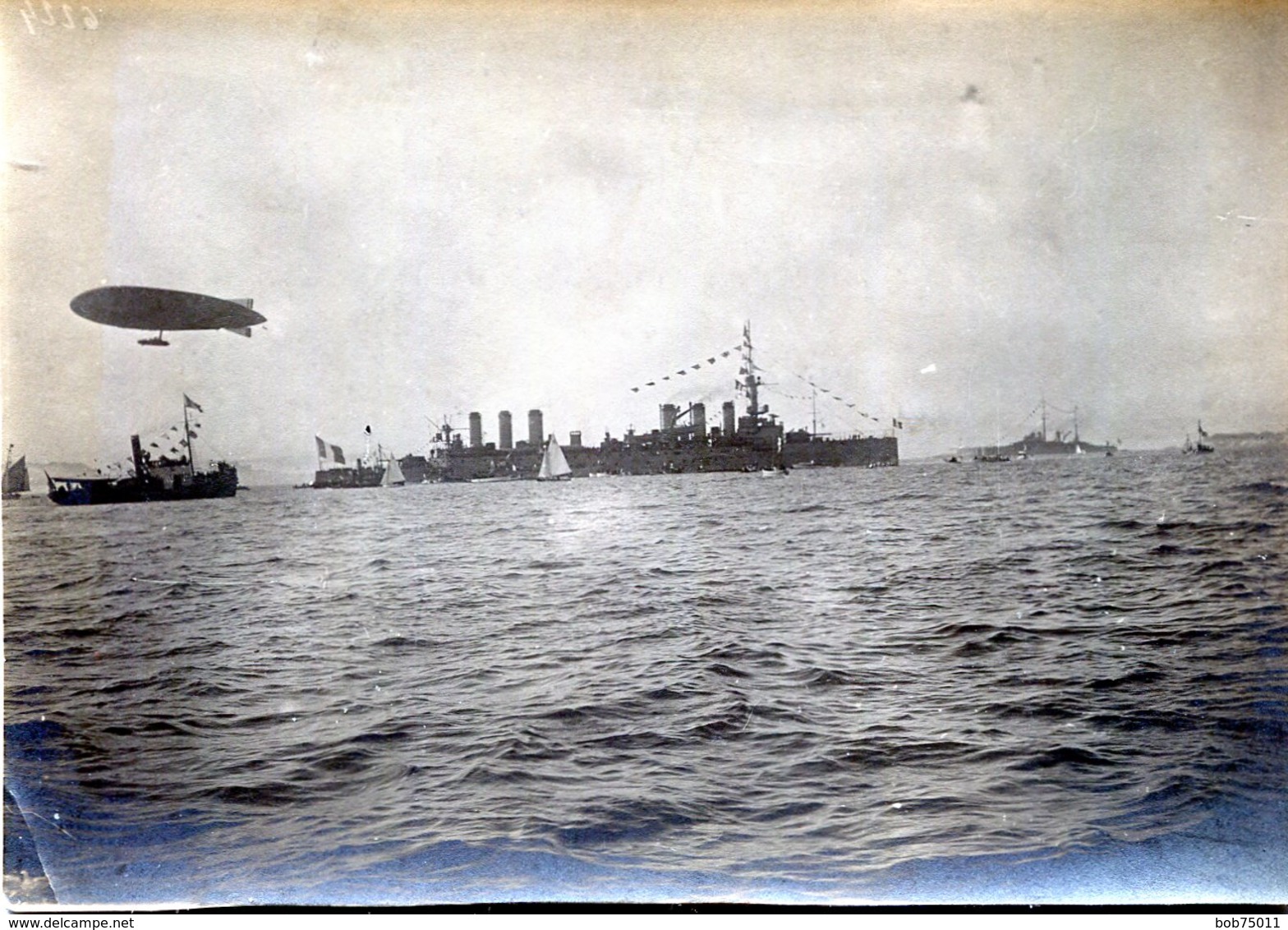 Belle Photo D'un énorme Navire De Guerre Escorté Par D'autre Navire Et Un Dirigeable - Bateaux