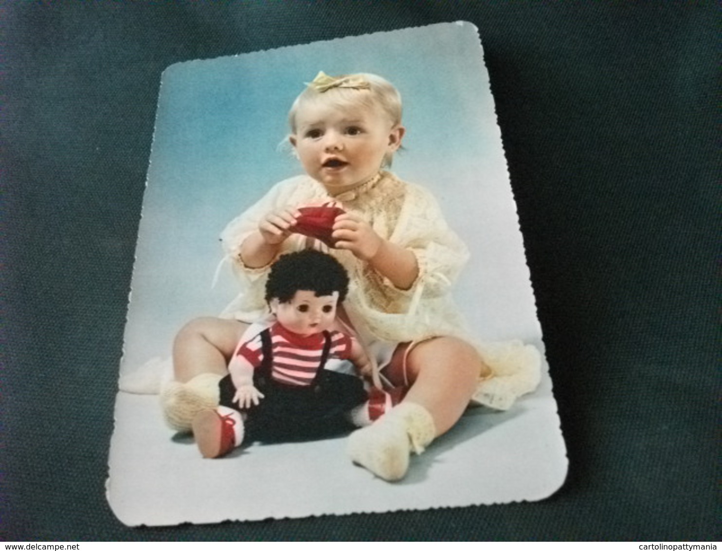 BAMBINA CON BAMBOLA MENTRE METTE CAPPELLO - Giochi, Giocattoli