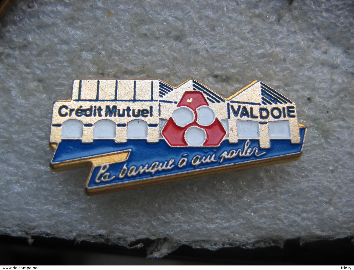 Pin's De La Banque Du Crédit Mutuel De La Commune De VALDOIE (Dépt 90). La Banque à Qui Parler - Banques