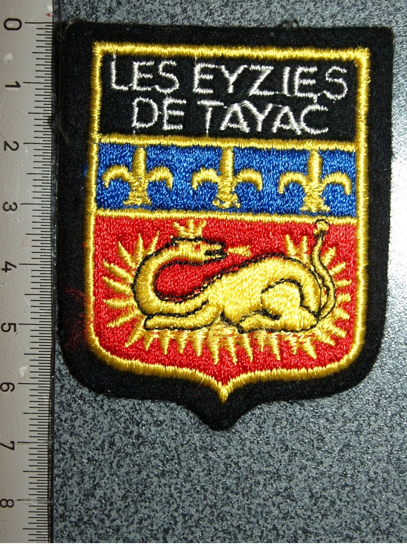 ECUSSON  TOURISTIQUE TISSUS LES EYZIES  DE TAYAC - Blazoenen (textiel)