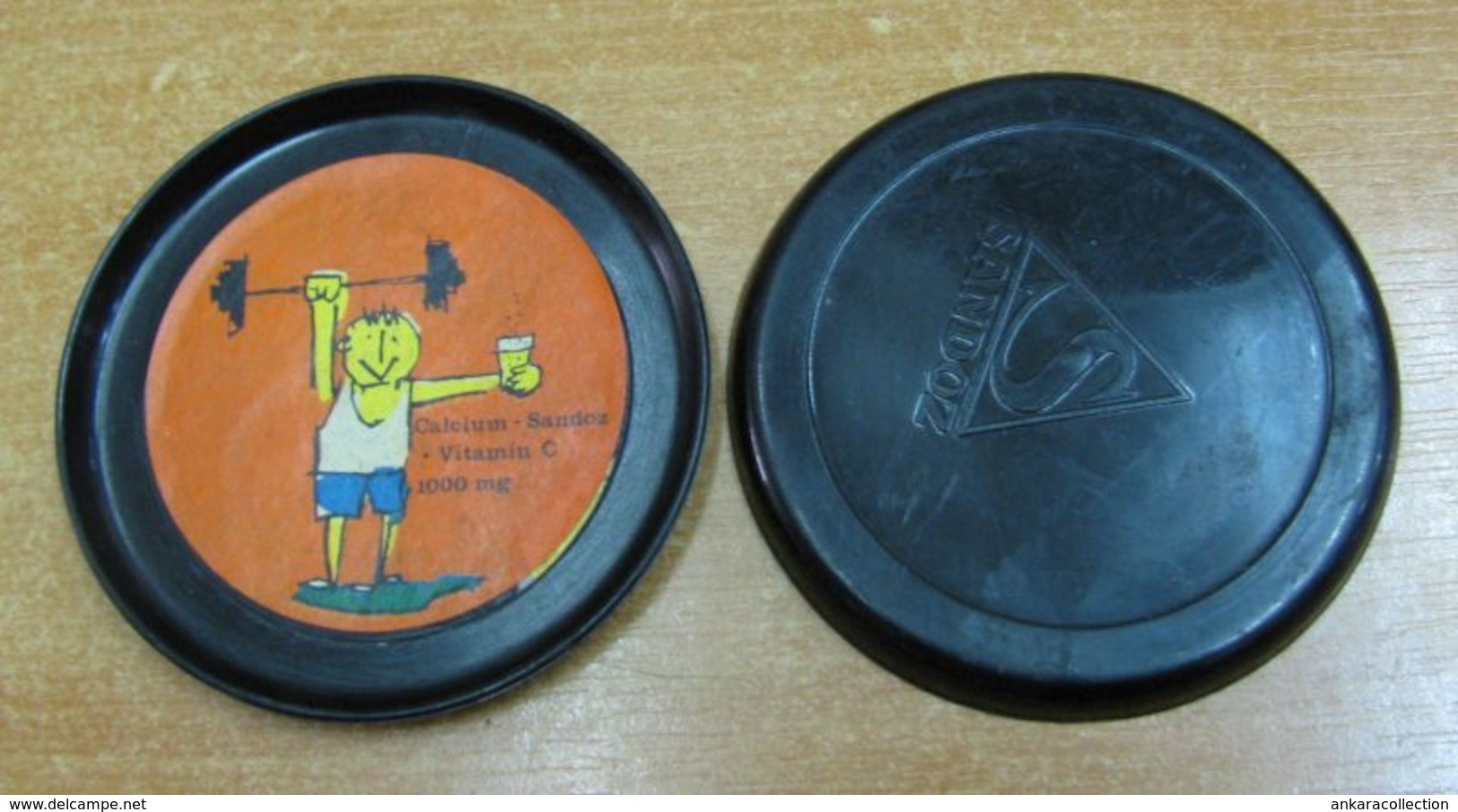 AC -  CALCIUM SANDOZ VINTAGE SAUCER TYPE PLASTIC COASTER - WEIGHTLIFTER - Ancient Tools