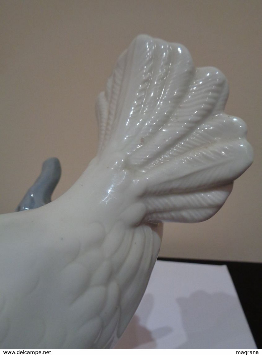Figura de porcelana de una Paloma blanca encima de una rama.