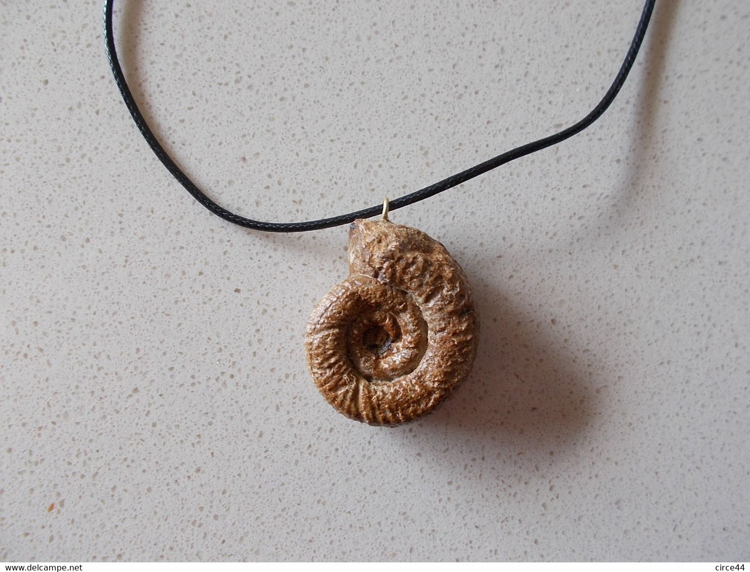 NOEL.CADEAU  ORIGINAL.AMMONITE  FOSSILE MONTEE EN PENDENTIF.LONGUEUR DU CORDON REGLABLE.ORIGINE MAINE ET LOIRE. - Fossiles