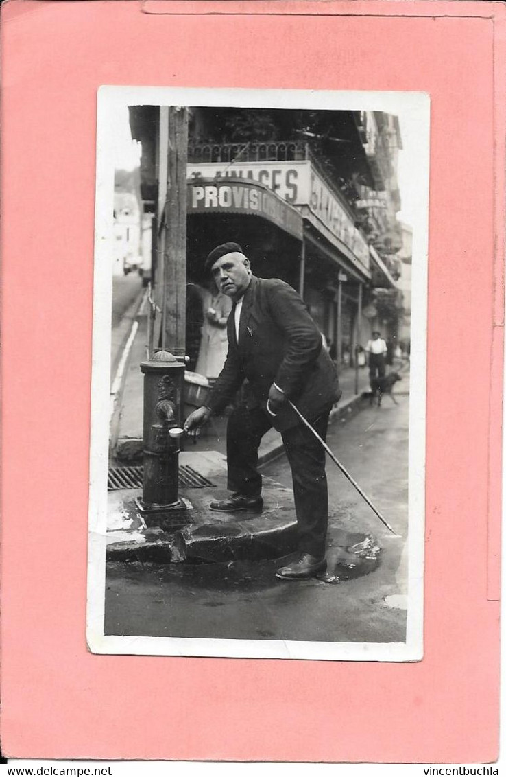 Photo Homme Prenant De L'eau à Une Fontaine De Ville Devant Un Magasin En Centre Ville (à Localiser) - Andere & Zonder Classificatie