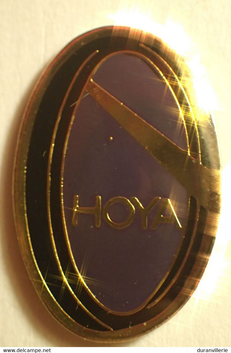 Pin's HOYA, FABRICANT VERRES OPHTALMIQUES POUR VOS YEUX. EMERAINVILLE FRANCE - Pattinaggio Artistico