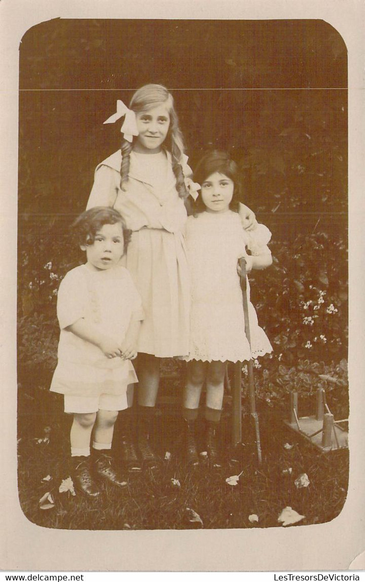 CPA - PHOTOGRAPHIE - Trois Enfants Réunis Sur Une Photo De Famille Dans Le Jardin - Noeud Dans Les Cheveux - Grupo De Niños Y Familias