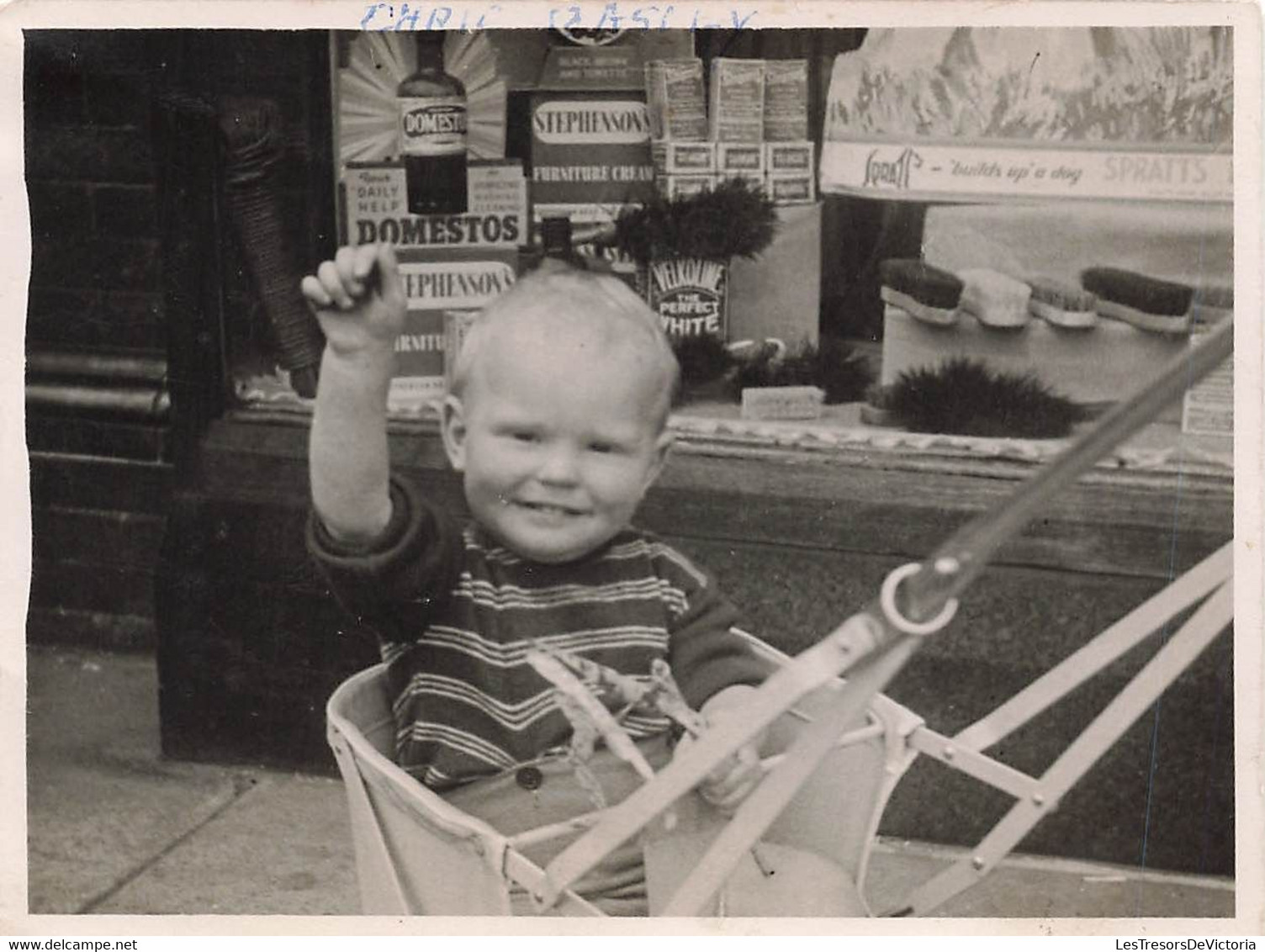 Photo De Chris Basley En Poussette Devant Une Vitrine Avec Des Publicités - Brosse - Domestos - Article De Ménage - 11x8 - Objetos