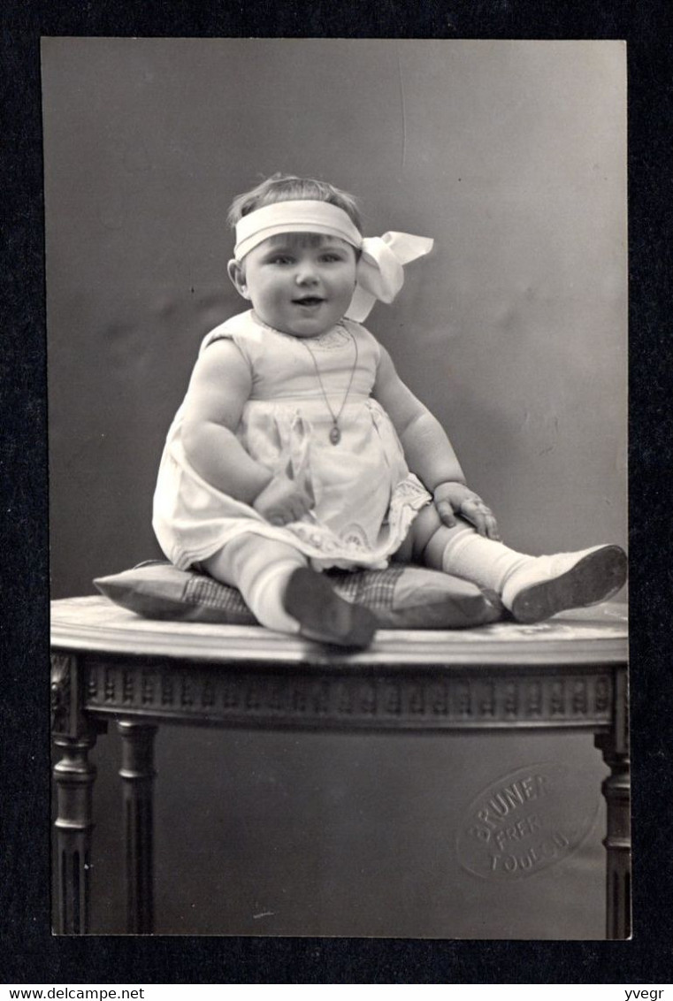 Belle Carte-Photo D'une Belle Fillette D'un An Assise Sur Une Console (24 Février 1932) (photo BRUNER Frère 31 Toulouse) - Genealogy