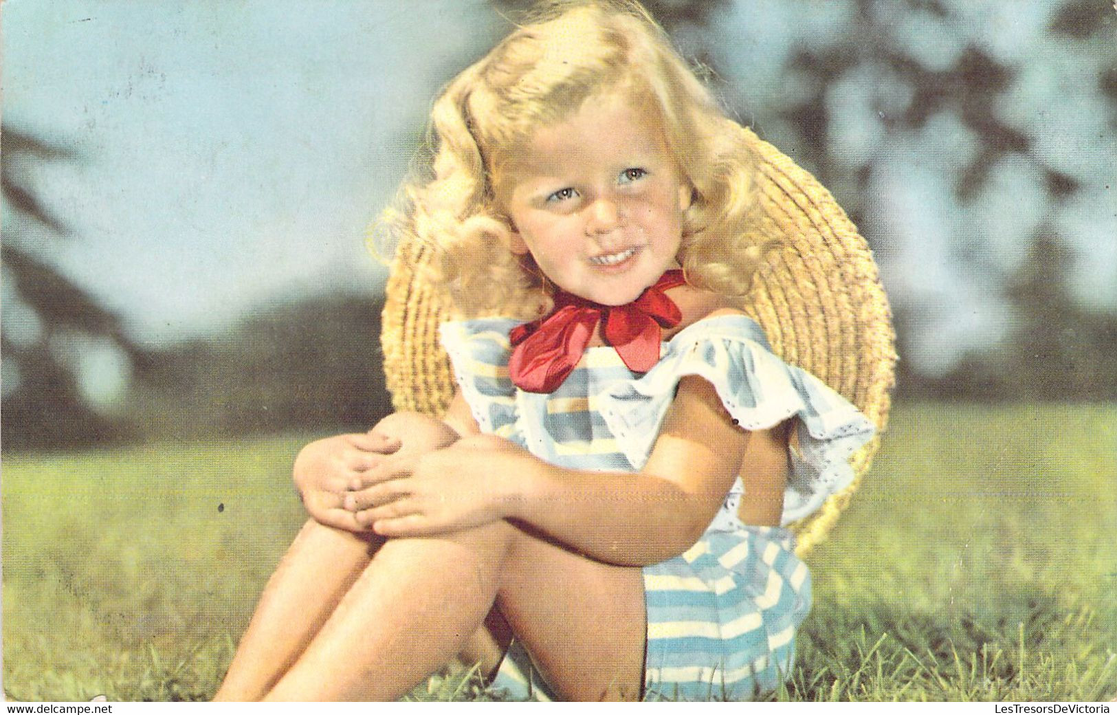 ENFANT - Fillette Blonde Au Chapeau Et Robe Rayée Bleue Assise Dans La Prairie - Noeud Rouge - Carte Postale Ancienne - Portraits