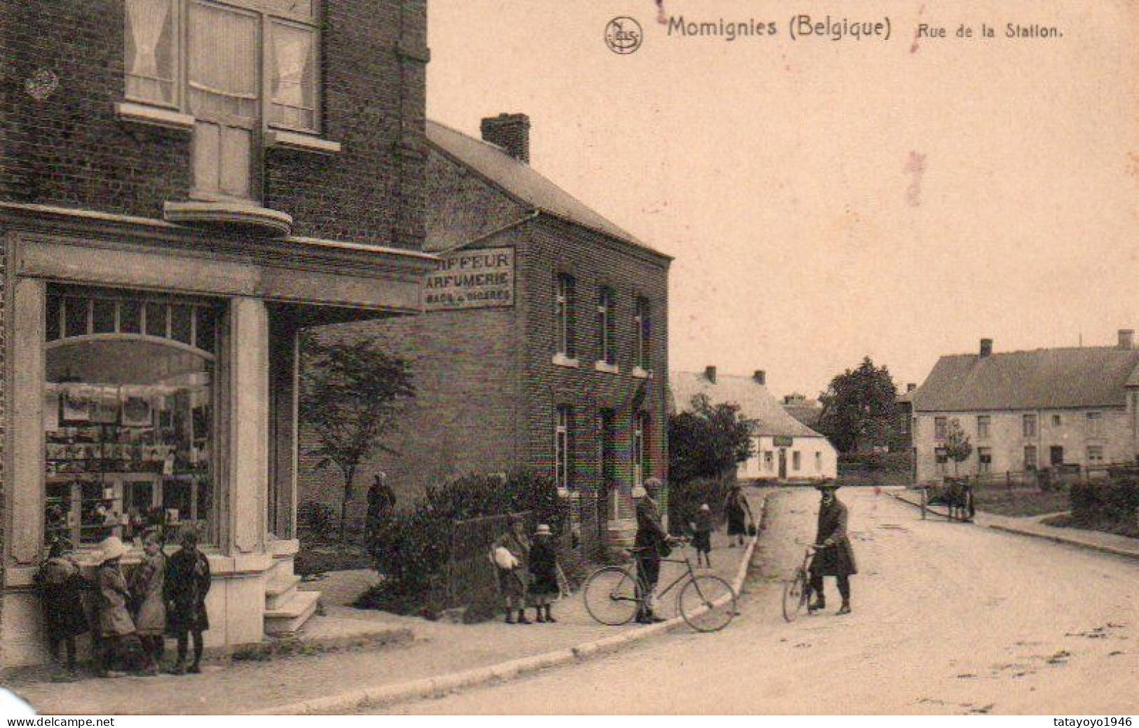 Momignies (belgique) Rue De La Station Animée Cyclistes Magasin Coin Inferieur Gauche Pliée  Lors Du Sca Voyagé En 1929 - Momignies