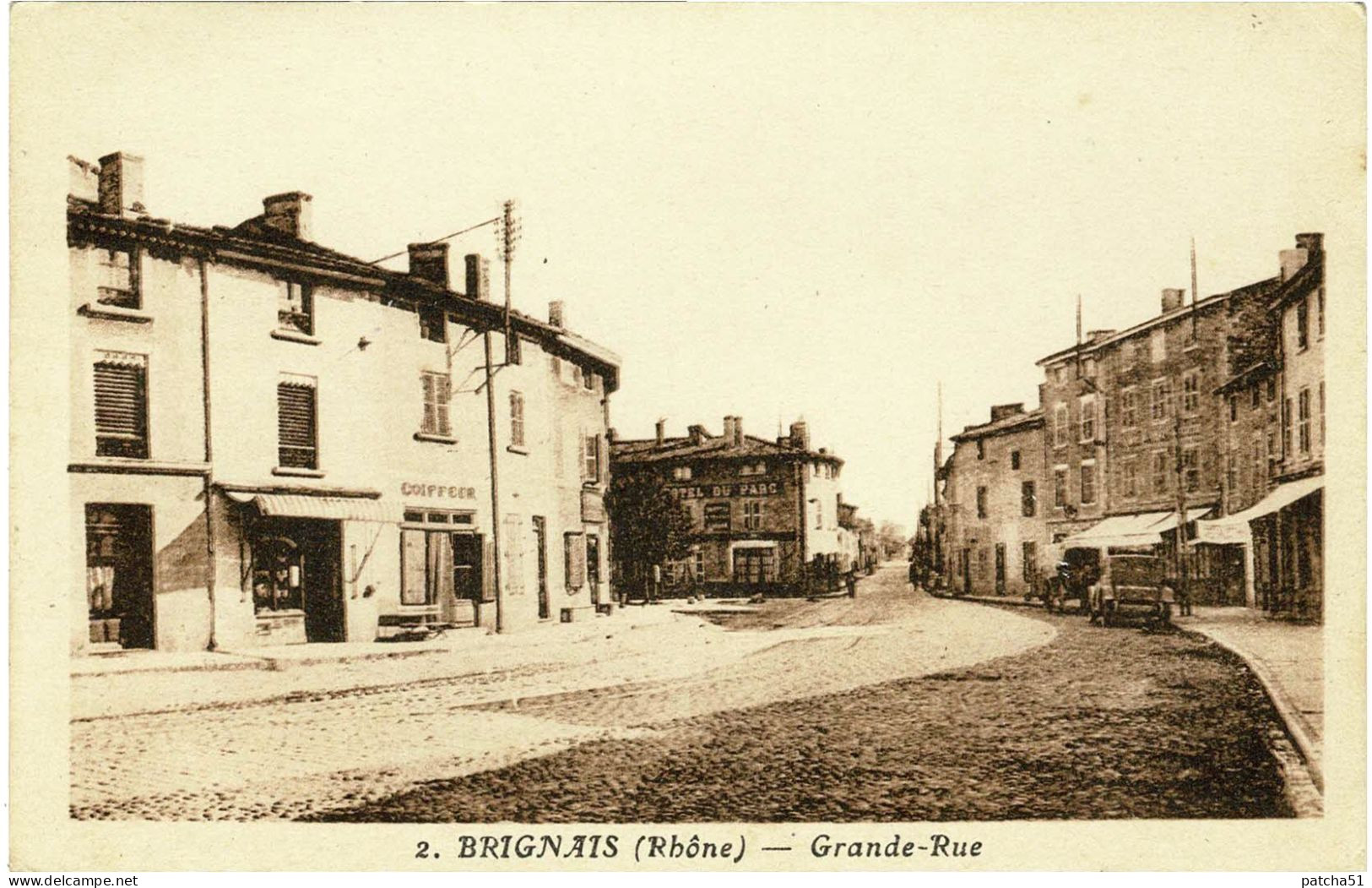 BRIGNAIS - Grande-Rue - Devanture De Coiffeur, Au Fond Hôtel Du Parc, Véhicules Anciens Stationnés - Brignais