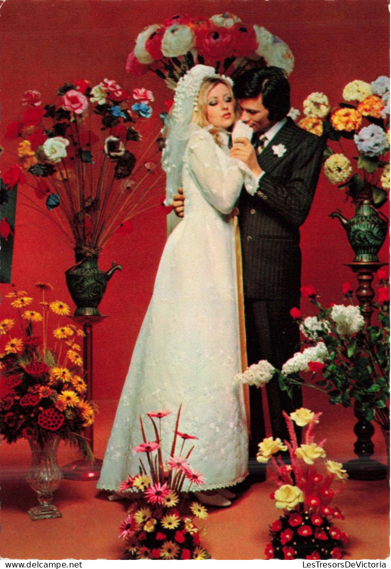 NOCES - L'époux Et La Mariée - Des Mariés Entourés De Fleurs - Murs Rouges - Colorisé - Carte Postale - Hochzeiten