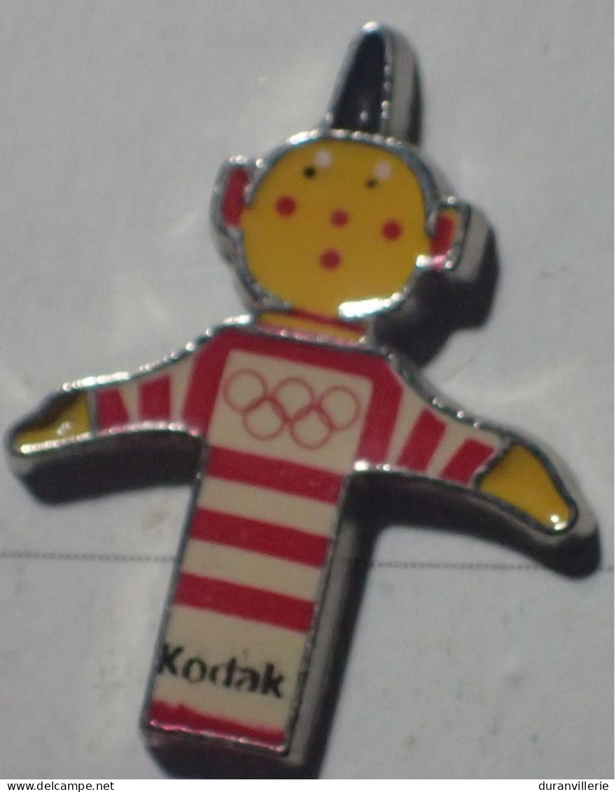 Pin's JO Jeux Olympiques - Kodak - Anneaux - Photo Pellicule Mascotte - Photographie