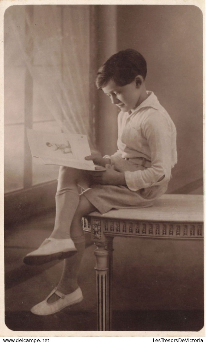 ENFANT - Petit Garçon Assis Sur Une Table Regardant Un Livre D'images - Carte Postale Ancienne - Altri & Non Classificati