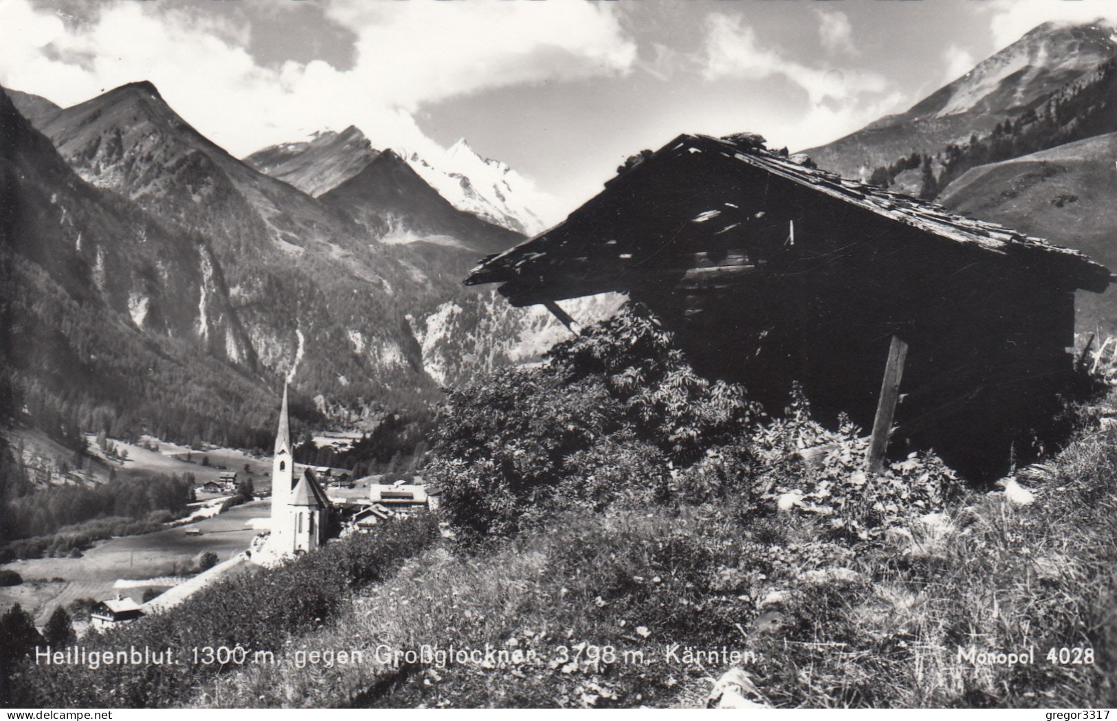 E343) HEILIGENBLUT Gegen Großglockner - Kärnten - FOTO AK Mit Holzhütte Vorne Und Blick Gegen Kirche - Heiligenblut