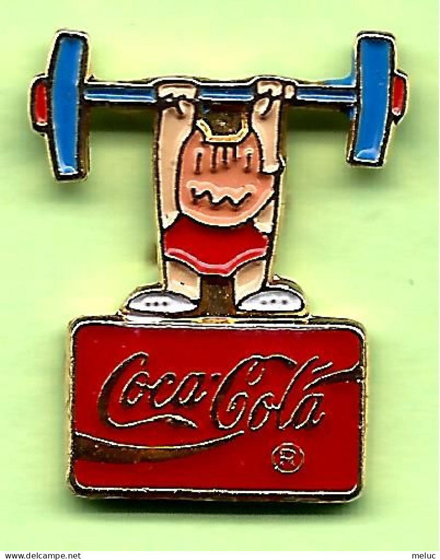 Pin's Coca-Cola Mascotte Cobi Haltérophilie (Barcelone) - 9T23 - Coca-Cola