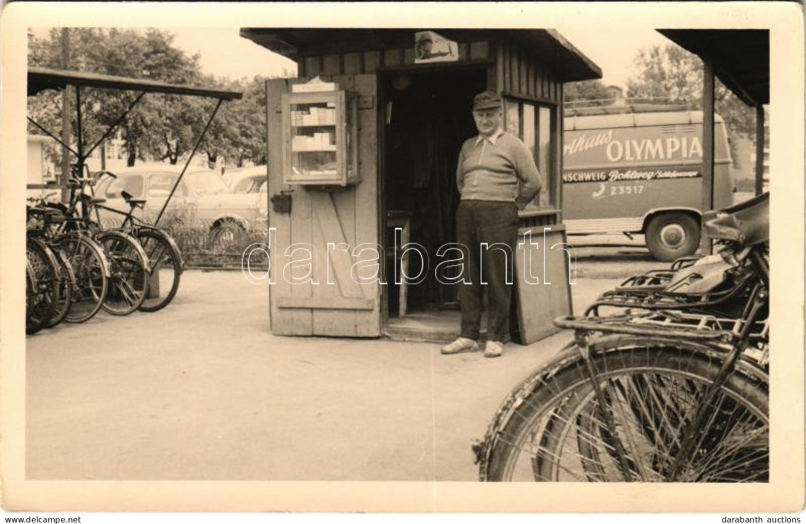 ** T1 Braunschweig, Brunswick; Fahrradabstellanlage Mit Parkwächter / Kerékpár Parkoló Parkolóőrrel, Háttérben Arthaus O - Unclassified