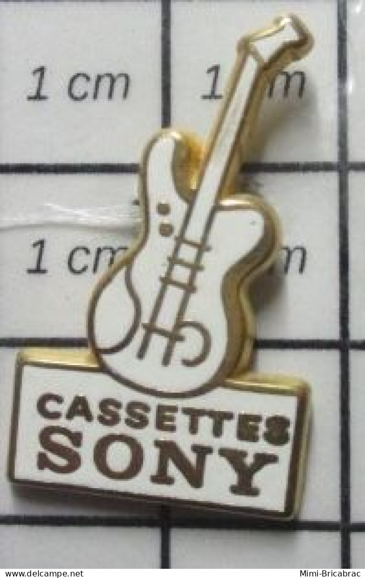 1616A   Pin's Pins / Rare Et De Belle Qualité / MUSIQUE / CASSETTES SONY GUITARE A 2 CORDES POUR BASSISTE !! - Musique