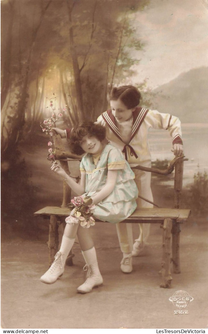 FANTAISIES - Deux Enfants - Une Jeune Fille Tenant Un Bouquet De Fleur Assise - Un Jeune Garçon - Carte Postale Ancienne - Cartoline Con Meccanismi