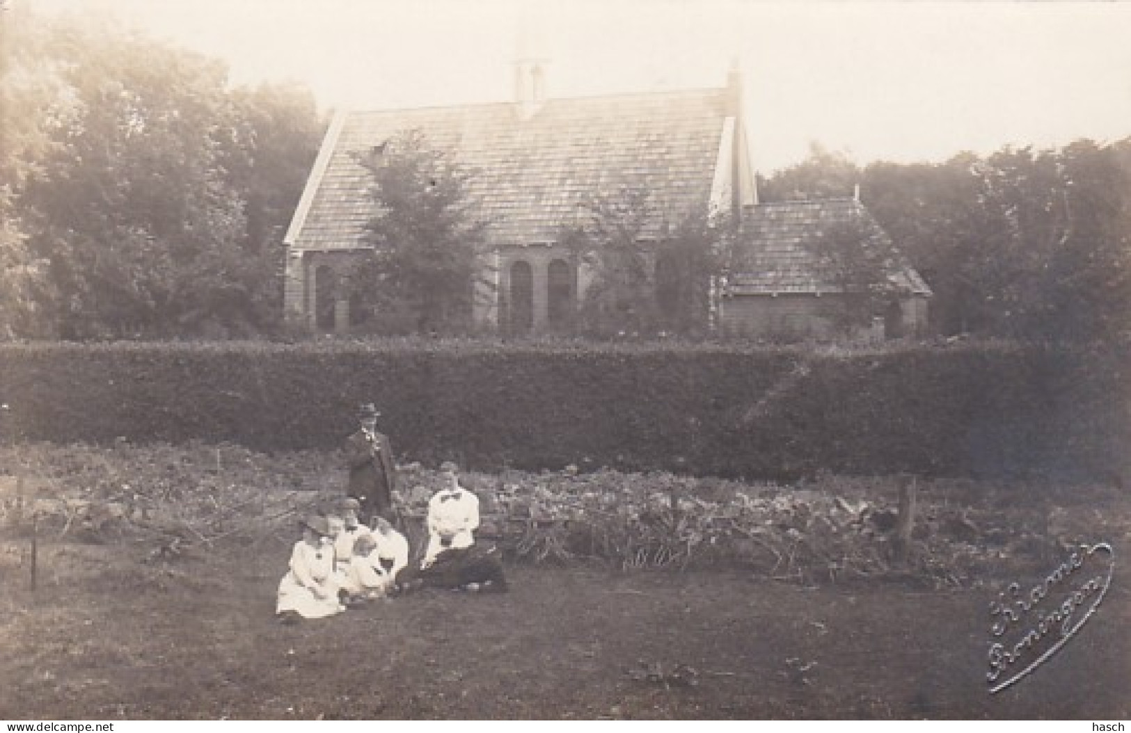 486054Schiermonnikoog, Familie In De Tuin Met Op Achtergrond Gereformeerde Kerk. (Fotograaf Piet Kramer (zie  - Schiermonnikoog