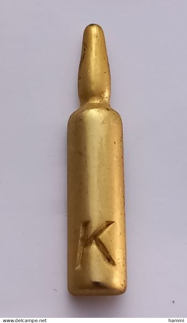 A81 Pin's Doré Parfum Parfume Tube K Ou Produit De Soin Kerastase  ? Qualité Zamac Signé Alcara Achat Immédiat - Perfume