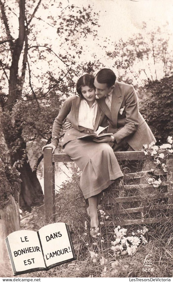 COUPLE - Le Bonheur Est Dans L'amour - Lire Un Livre - Femme Assise Sur Une Clôture - Carte Postale Ancienne - Paare