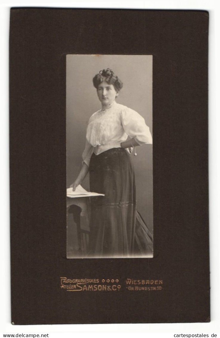 Fotografie Samson & Co., Wiesbaden, Portrait Dame In Weisser Bluse Mit Dutt U. Zeitung An Tisch Gelehnt  - Personnes Anonymes