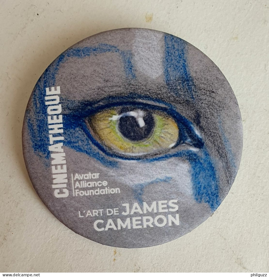 BADGE L'ART DE JAMMES CAMERON AVATAR 2024 - Objets Publicitaires