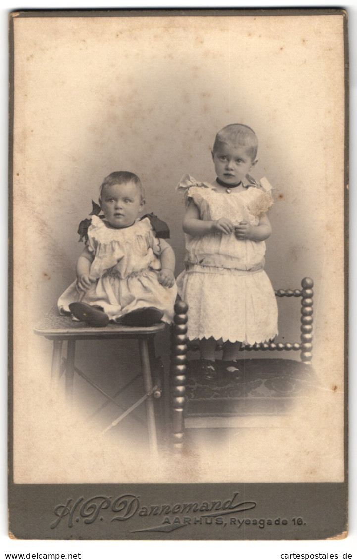 Fotografie H. P. Dannemand, Aarhus, Ryesgade 16, Zwei Süsse Kleine Mädchen In Weissen Kleidern, Neugierig U. Schüch  - Personnes Anonymes