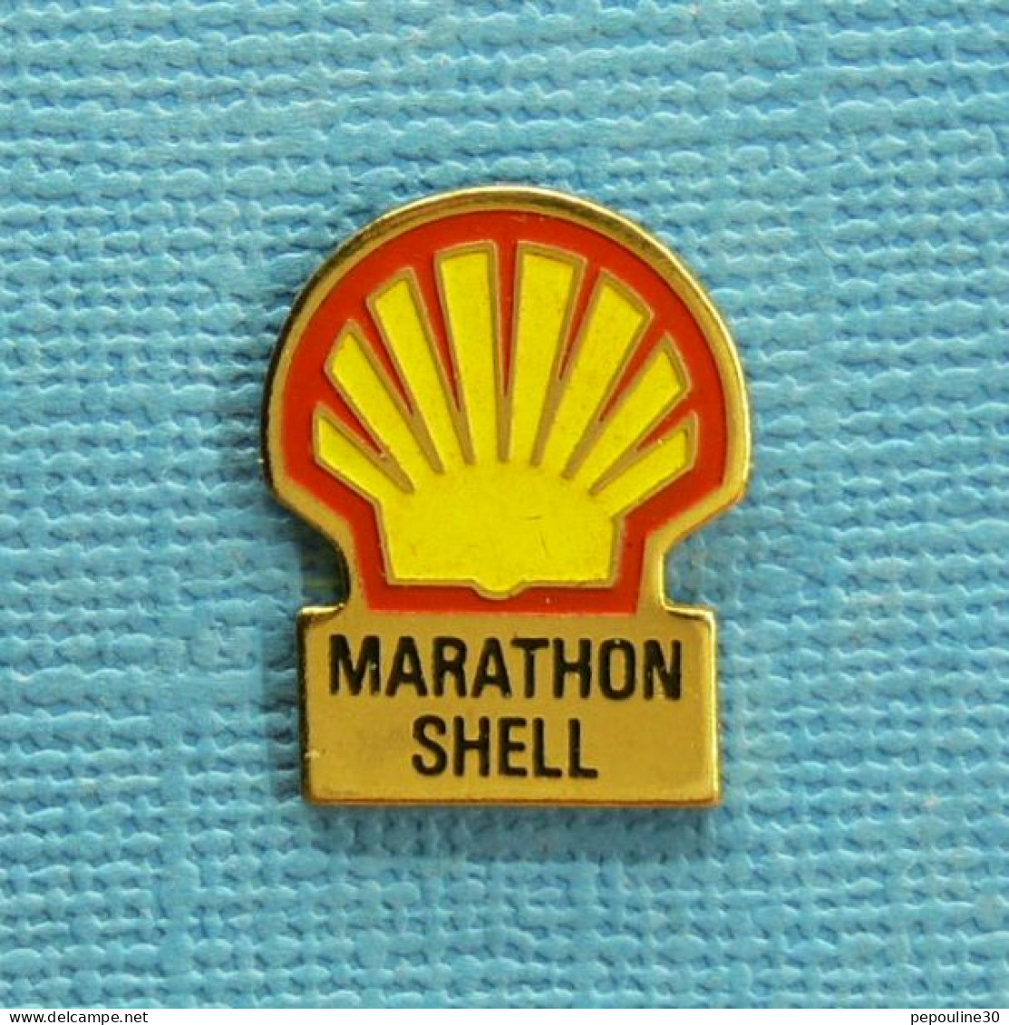 1 PIN'S /  ** MARATHON " SHELL " PARCOURIR LA PLUS LONGUE DISTANCE AVEC 1L DE CARBURANT ** . (B.I. Promocourse) - Autres & Non Classés