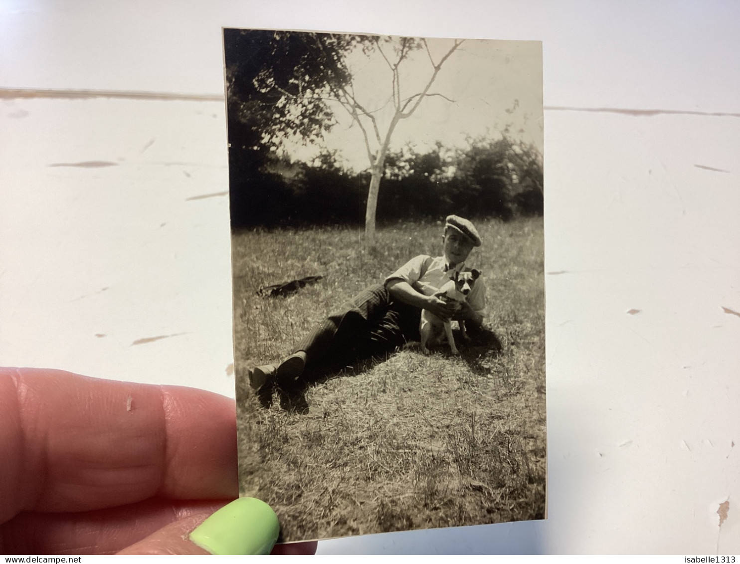 Photo Snapshot 1930 Cannes Homme Couché Par Terre, Bien Habillé Béret Avec Son Chien Dans Les Bras Dans L’herbe Arbre Fo - Anonyme Personen