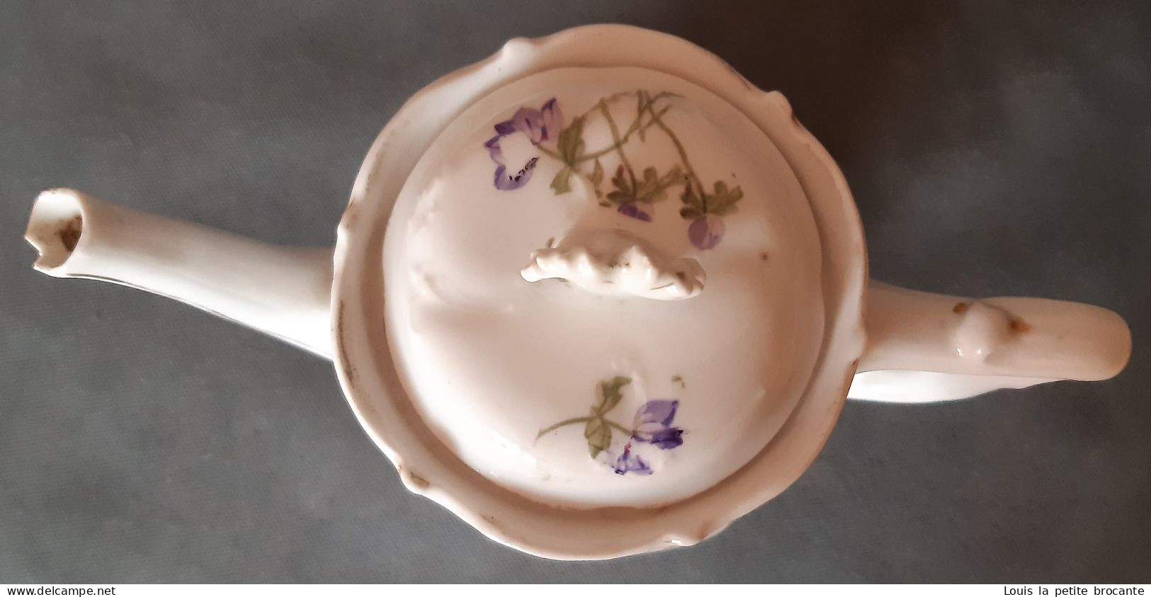 Cafetière En Porcelaine, Blanche Motif Floral Violet. Un Casse Sur Le Bec Verseur. - Altri & Non Classificati