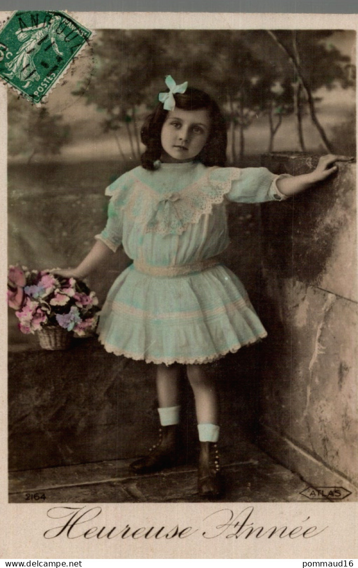 CPA Heureuse Année : Petite Fille Vêtue De Bleu, Noeud Dans Les Cheveux Et Tenant Un Panier Rempli De Fleurs - Anno Nuovo